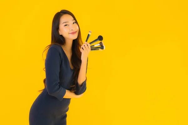 Retrato Bela Jovem Asiático Mulher Com Maquiagem Escova Amarelo Isolado — Fotografia de Stock