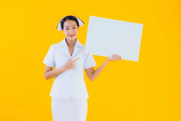 年轻美丽的亚裔妇女 泰国人护士 空荡荡的白板 在孤立的黄色背景下 在诊所或医院工作 — 图库照片