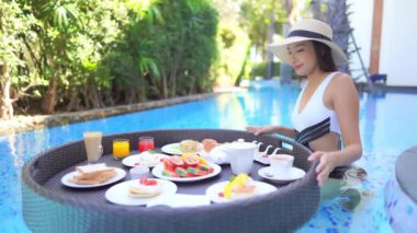 Güzel Asyalı bir kadının oteldeki havuzda dinlenirken çekilmiş görüntüleri.