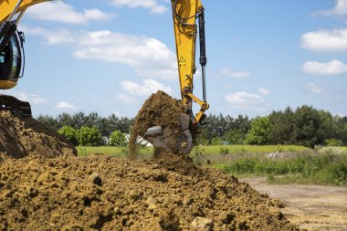 Sarı Ekskavatör inşaat alanında yere yükler