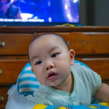 Tatlı ve yakışıklı Asyalı erkek bebek ya da bebek bir şeyle oynuyor.