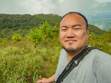 Sukhothai bölgesindeki Ramkhamhaeng Ulusal Parkı 'ndaki Khao Luang Dağı' ndaki Asyalı şişko yürüyüşçünün selfie fotoğrafı.