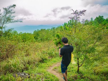 Trekker 'ın arkası, Tayland' ın Ramkhamhaeng Milli Parkı 'ndaki Khao Luang Dağı' nda yürüyor.