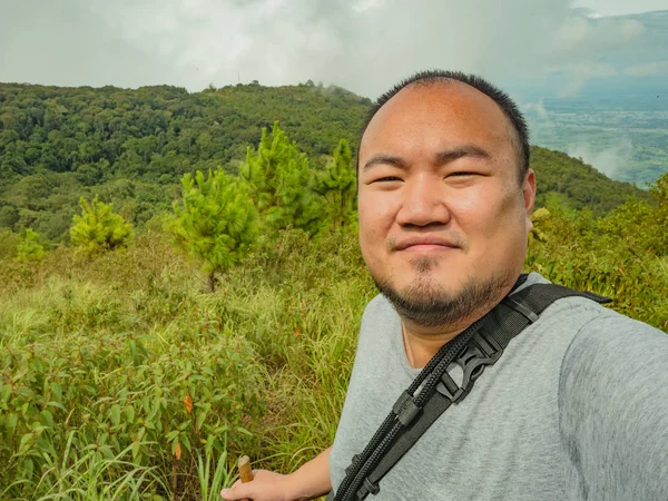 Sukhothai bölgesindeki Ramkhamhaeng Ulusal Parkı 'ndaki Khao Luang Dağı' ndaki Asyalı şişko yürüyüşçünün selfie fotoğrafı.