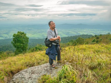 Tayland 'ın Sukhothai bölgesindeki Ramkhamhaeng Ulusal Parkı' nda Khao Luang dağında Asyalı Şişman bir gezgin yürüyüş yapıyor.