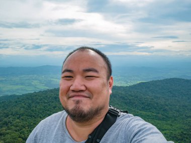 Sukhothai bölgesindeki Ramkhamhaeng Ulusal Parkı 'ndaki Khao Luang Dağı' ndaki Asyalı şişko yürüyüşçünün selfie fotoğrafı.