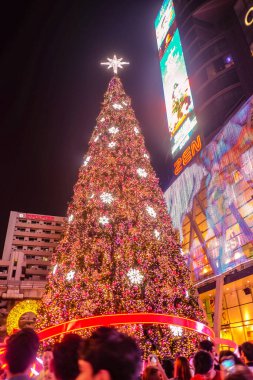 Bangkok / Tayland - 24 Aralık 2015: Noel arifesinde yürüyen turistle birlikte Central World kalkış mağazasının önündeki Noel Ağacı. Bangkok Şehri Tayland