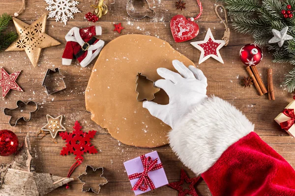 サンタ クロース クリスマス ベーカリー コンセプト背景ベーキング クッキー菓子麺棒形カッターと素朴な木製のテーブルに赤い装飾 — ストック写真