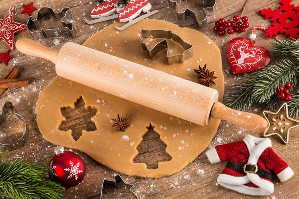 クリスマス ベーカリー コンセプト背景ベーキング クッキー菓子麺棒形カッターと素朴な木製のテーブルに赤い装飾 — ストック写真