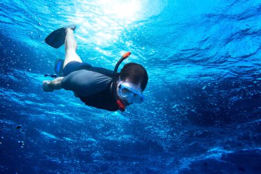 Genç dalış snorkeling güneş ışığına karşı derin mavi okyanus denize adam düştü