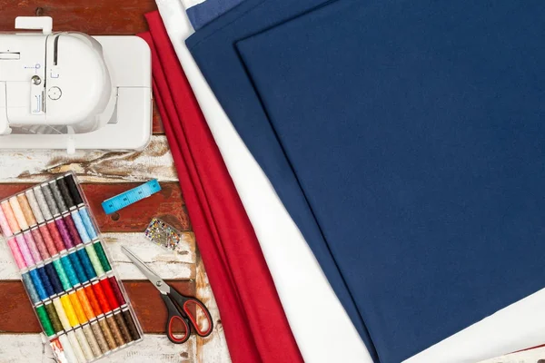 ミシン青白赤い布はさみボックス カラフルなコットンの素朴な木製のテーブルにテープやピンの針を測定 — ストック写真