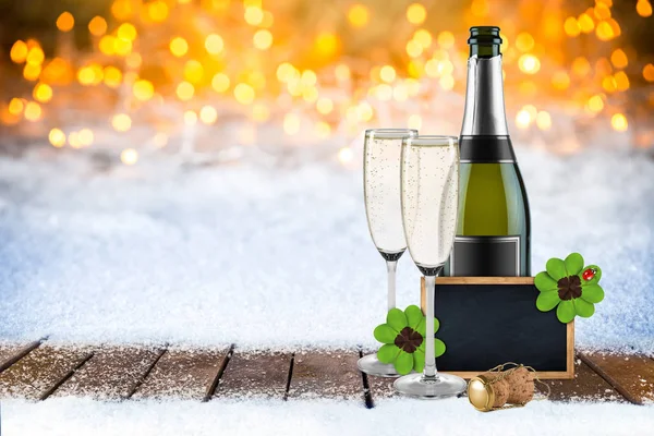 new years eve champagne bottle glasses and empty slate blackboard chalkboard wooden frame decorated with  four leaf clover and ladybug snow bokeh background