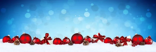 白いクリスマス プレゼント ギフト ボックスと背景のボケ味の青のマツ円錐形の赤いクリスマス安物の宝石ボール行 — ストック写真