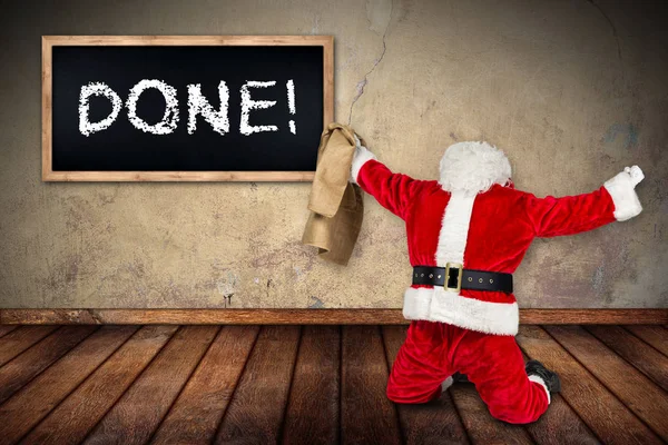滑稽的疯狂滑稽的红色白色圣诞老人庆祝握紧拳头拿着袋子在空中工作做了黑板在木地板内部房间 — 图库照片