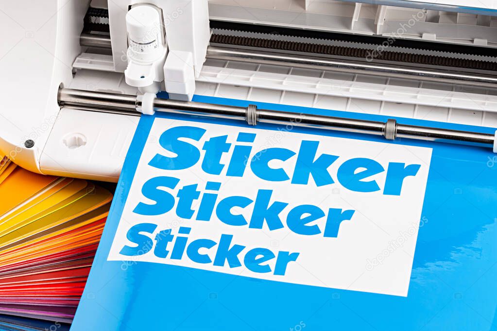 production making sticker with plotter cutting machine on cyan blue colored vinyl fim with color fan. guide. Advertising Industry diy design concept background.