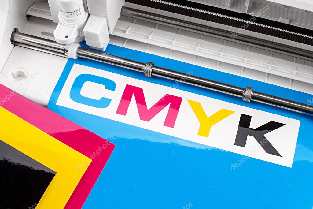 production making CMYK sticker with plotter cutting machine on cyan blue colored vinyl film Advertising Industry diy design on concept background.
