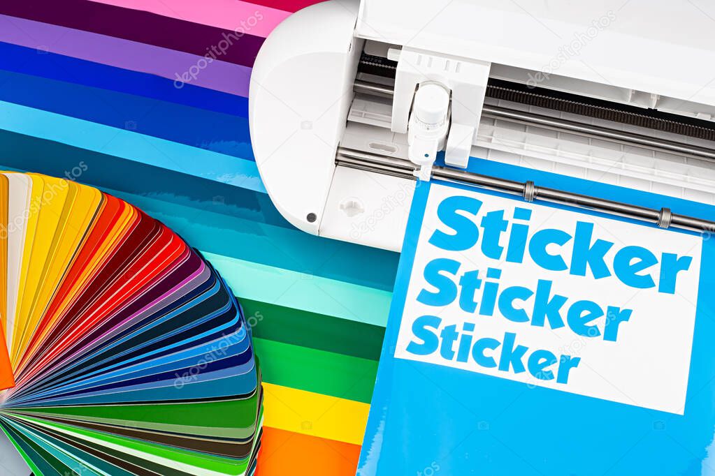 production making sticker with plotter cutting machine on sheets of colorful various rainbow colored vinyl fim with color fan. guide. Advertising Industry diy design concept background.