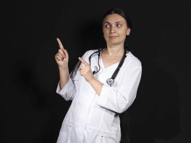 Kadın doktor el hareketlerini ve siyah arka planda poz veriyor.