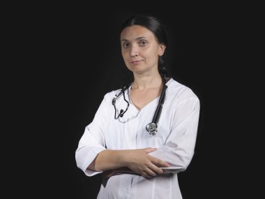 Kadın doktor el hareketlerini ve siyah arka planda poz veriyor.