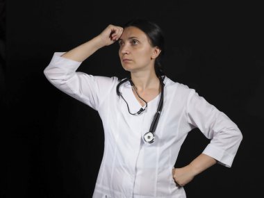Kadın doktor el hareketlerini ve siyah arka planda poz veriyor.