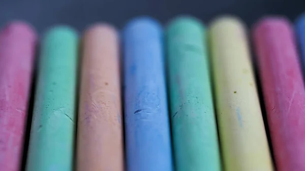 Selective focus on crayons for drawing on asphalt in different colors