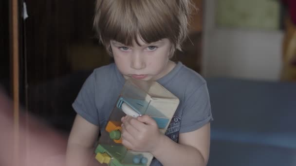 Een kleine jongen kijkt naar iets intens — Stockvideo
