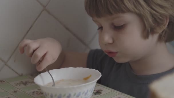 Un petit garçon mange à table — Video
