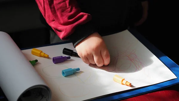 Un niño dibuja con lápices sobre papel blanco — Foto de Stock