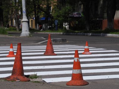 Gri asfalt üzerinde yaya geçidi olan beyaz trafik işaretleri.