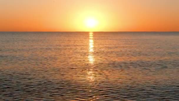 Солнце поднимается над спокойным морем — стоковое видео