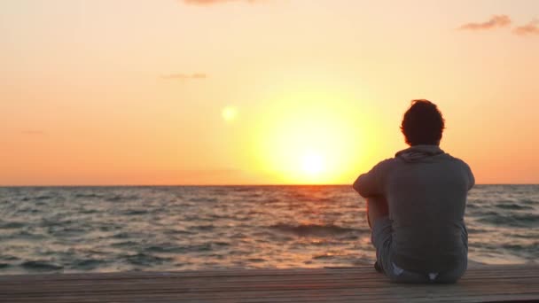 Primer plano de un hombre mirando un amanecer al final del día — Vídeos de Stock