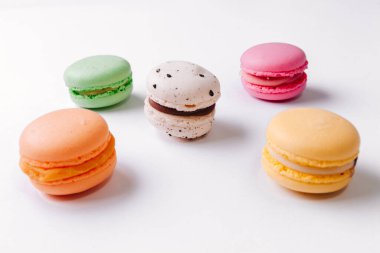 Beyaz arka planda makarna deseni. Renkli Fransız tatlıları. Üst Manzara. Düz yatıyordu