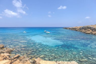 Gök mavisi deniz ve kayalarla kaplı deniz burnu, Ayia Napa Mavi Göl.