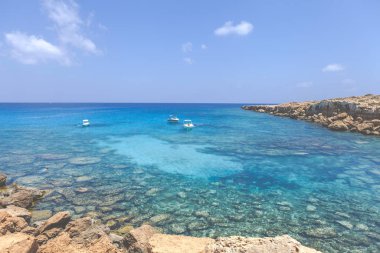 Gök mavisi deniz ve kayalarla kaplı deniz burnu, Ayia Napa Mavi Göl.