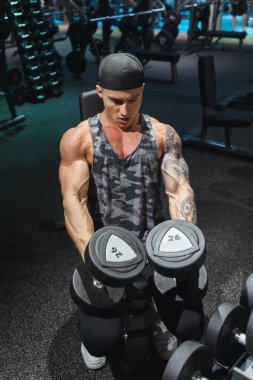 Spor giyim sektöründe formda genç bir adam spor salonunda bir halteri kaldırmaya odaklanmıştı..