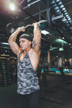 Vücut geliştirici, halterli vücut geliştirmede halterciyle vücut geliştirme egzersizi yapıyor. Fitness kaslı vücut.