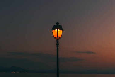 Yunanistan 'da akşam batımı. Fenerin içinde ışık parlıyor..