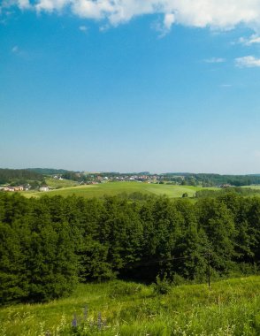 Tepeler, tarlalar ve çayırlar. Wiezyca 'nın güzel manzarası, Kashubia Bölgesi, Kuzey Polonya. Boşluğu mavi gökyüzünde kopyala.