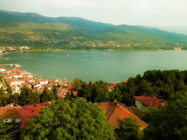 Ochrid şehrinden Ochrid Gölü kıyısında görüldü. Ochrid, Avrupa 'nın bilinen en eski gölüdür, temiz ve şeffaf sudur. Ohri ve Ohri Gölü UNESCO 'nun doğal ve kültürel mirasları. Tipik Makedon mimarisi. Seyahat ve Mimarlık dolandırıcılığı