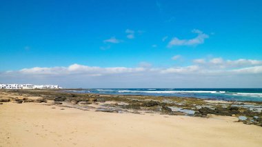 Caleta de Famara 'daki Plaj ve Atlantik Okyanusu, Lanzarote Kanarya Adaları. Caleta de Famara 'daki plaj sörfçüler arasında çok popülerdir. Boşluğu kopyala.