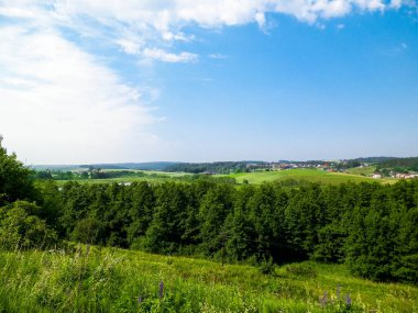 Tepeler, tarlalar ve çayırlar. Wiezyca 'nın güzel manzarası, Kashubia Bölgesi, Kuzey Polonya. Boşluğu mavi gökyüzünde kopyala.
