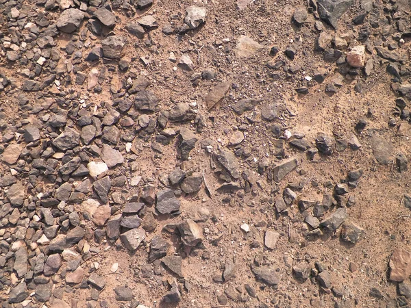 Kahverengi, Kanarya çölü ve arka plan olarak kayalar. Tipik Lanzarote adası toprağı. Boşluğu kopyala, doğa kavramı.