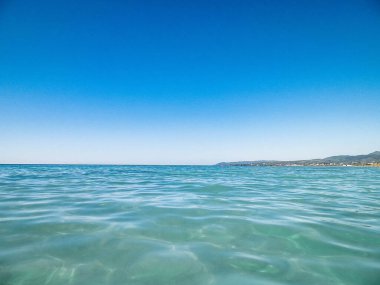Mavi, şeffaf Tyrhenian deniz suyu mavi gökyüzü arka planında. Tatiller ve doğa konsepti. Boşluğu kopyala.