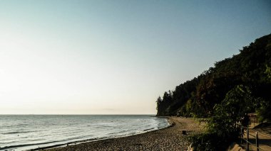 Orlowski Kayalıkları üzerinde gün doğumu ve Polonya 'nın Baltık Denizi kıyısında güzel kumlu bir sahil. Polonya doğası, tatiller ve turizm kavramı.