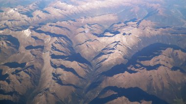 Alpler, uçağın penceresinden dağların manzarası. Toprak bükme ve doğa kavramı.