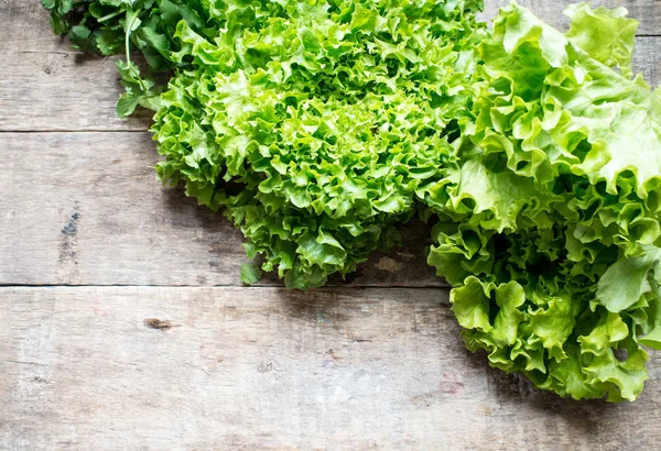 Grüner Salat auf einem Holzgrund — Stockfoto