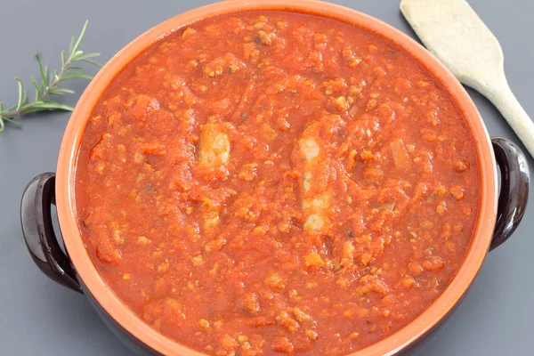 Bolognese sauce with sausage in terracotta pan — Stock Photo, Image