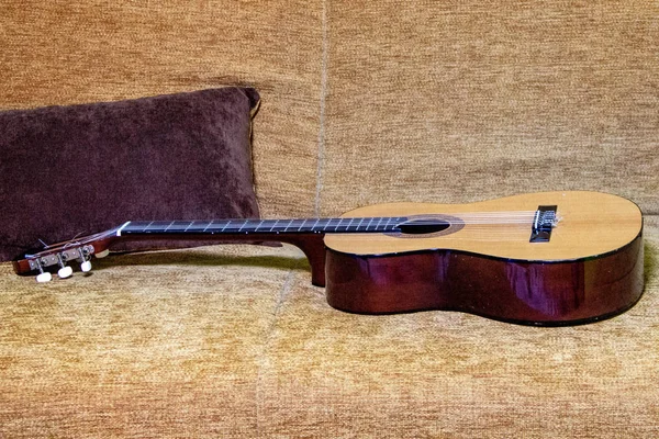 Drewniana Gitara Leży Beżowej Sofie Instrumenty Smyczkowe Domu — Zdjęcie stockowe