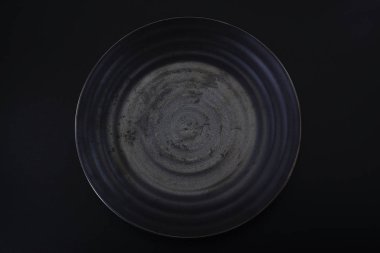 a dark grey ceramic plate with a water ripple