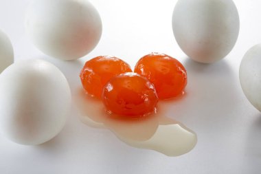 Üç tuzlu ördek sarısı ve bir yığın tuzlu ördek yumurtası.
